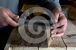 Carpenter measures with a caliper a wooden beam