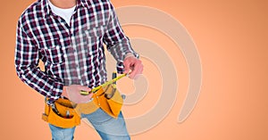 Carpenter with measuring tape against orange background