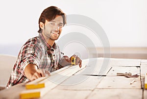 Carpenter, measuring tape and wood in workshop, smile and happiness for job, service and plan. Man, working and builder