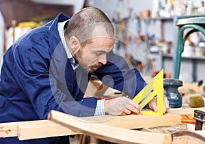 Carpenter measuring wooden plank