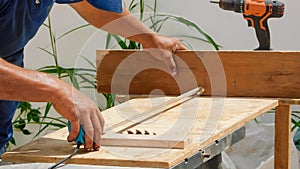 Carpenter measuring a wooden plank with a milometer