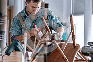 Carpenter painting wooden chair photo