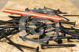 Carpenter pencil resting on discarded nails