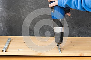 Carpenter placing screws with a drill