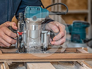 Carpenter planing a plank with a router