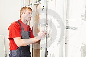 Carpenter with plasterboard and screwdriver