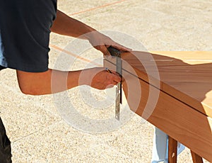 Carpenter pointing out the cut of a beech wood step with the metal carpentry square.