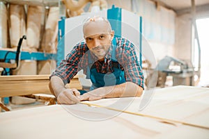 Carpenter processes wooden door, woodworking