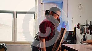 Carpenter putting safety glasses on while selecting quality wood materials