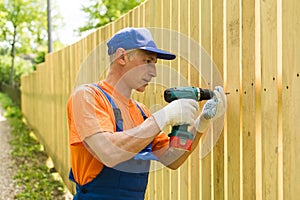 Carpenter ready to twirl the in wooden fence