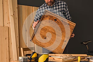 Carpenter repairing wooden drawer in woodwork workshop