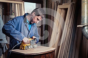 Carpenter restoring furniture with belt sander