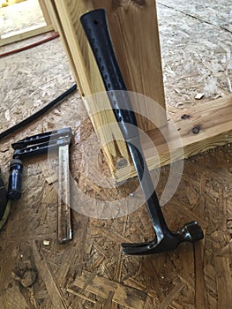 The carpenter`s hammer and the ribbing lying on the OSB board