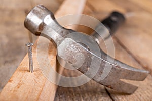 Carpenter& x27;s hammer and steel nails on a wooden workshop table. Small carpentry work in the workshop