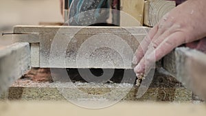 A carpenter's hand glides over a wooden slab, feeling the grain. This moment captures the artisan's