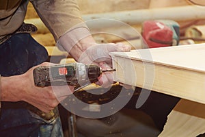 Carpenter`s Hands Man Worker Drilling Wood at Construction Site.