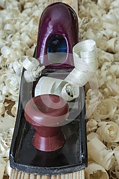 Carpenter`s tool metal plane on a board and wood shavings