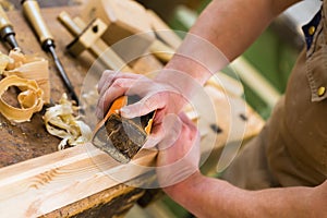 Carpenter with sanding block in carpentry