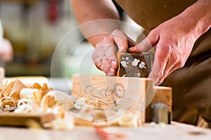 Carpenter with sanding block in carpentry