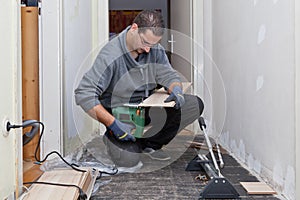 Carpenter sanding and cutting new floor boards