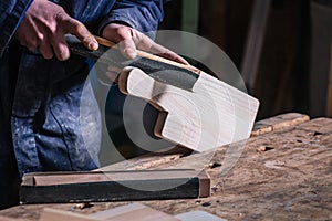 Carpenter sanding piece of Timber with sandpaper