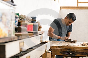 carpenter sanding a piece of wood. craft procedures with wood. Colombian man in his workshop