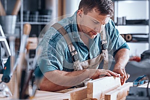 Carpenter sanding a wooden plank