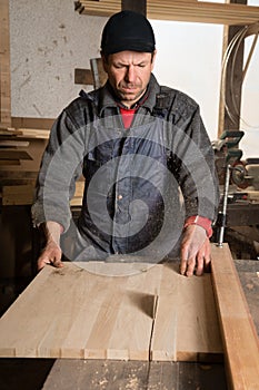Carpenter sawing a board in the circulation saw