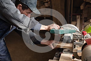 Carpenter sawing a board on a machine with a circulation saw