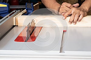 Carpenter saws wood on a tabelsaw in workshop ,woodworking concept. selective focus