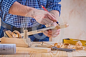 Carpenter scetching wooden plank construction