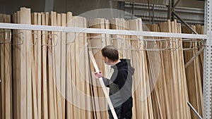 Carpenter Selecting Lengths of Cut Wood in Store