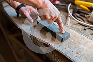 Carpenter sharpening a chisel in a small workshop