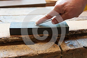 Carpenter sharpens a chisel photo