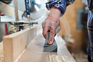 Carpenter sharpens a chisel in a small workshop,