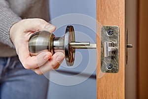 An Carpenter shoves the door handle spindle through the face bore and the latch assembly