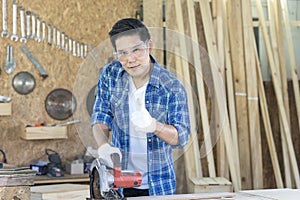Carpenter showing thumb up. Young male carpenter working wood workshop