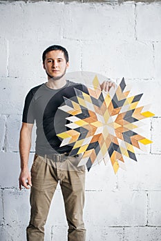 Carpenter standing with a wood product and looking at camera