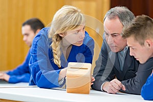 carpenter with students in workshop assembling wood