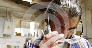 A carpenter taking off his safety googles