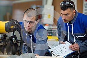 carpenter and teacher working with circular saw