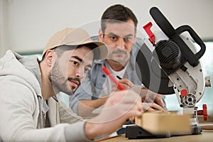 carpenter teaches his apprentice photo