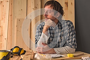 Carpenter thinking in small business woodwork workshop interior