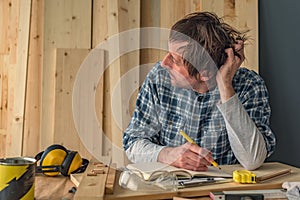 Carpenter thinking in small business woodwork workshop interior