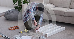 Carpenter tightening screw on wood at home