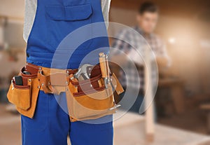 Carpenter with tool belt in workshop
