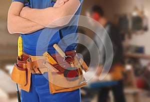 Carpenter with tool belt in workshop
