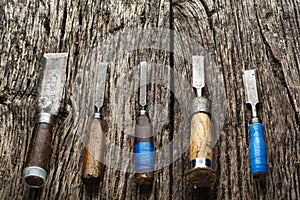 Carpenter tools composition. Old carpenter chisels laying on rustic wooden table upper view