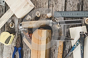 The carpenter tools on wooden bench, plane, chisel,mallet, tape measure, hammer, tongs, pliers, level, nails and a saw