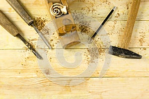 Carpenter tools on wooden table with sawdust. Craftperson workplace top view